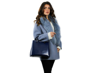 Model wearing sky blue TIAN overcoat from Pamo and holding a royal blue leather JANE handbag from Pamo
